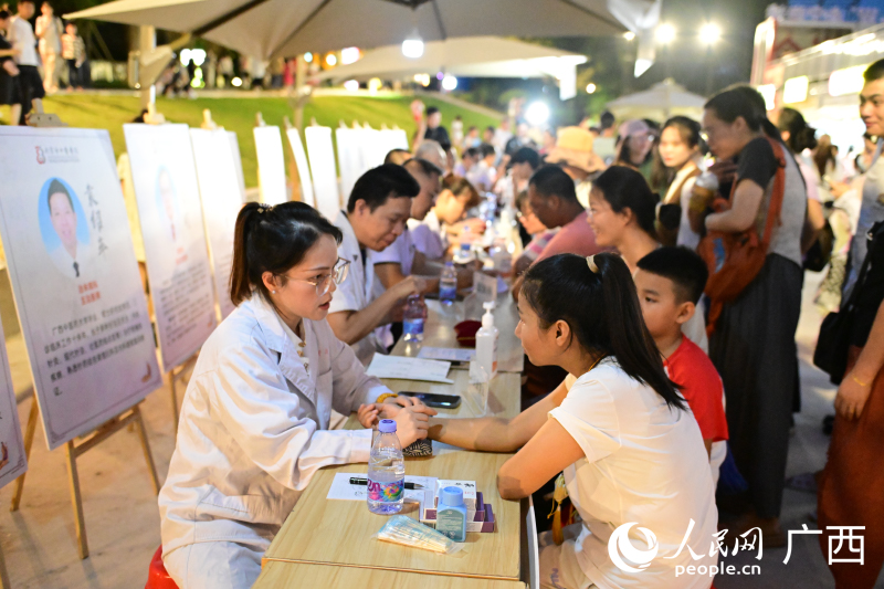 中医夜市中,市民排队体验诊疗服务。人民网 雷琦竣摄