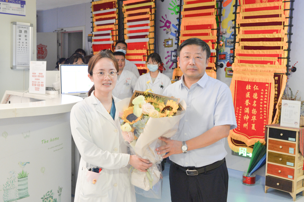 秦祖杰（右一）慰问针灸推拿学教研室教师代表林青琰（左一）