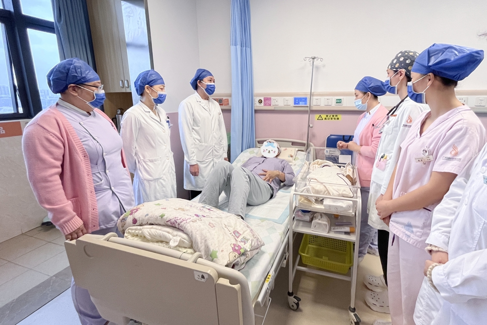 莫女士从重症监护室转至产科，医护人员查房看望。