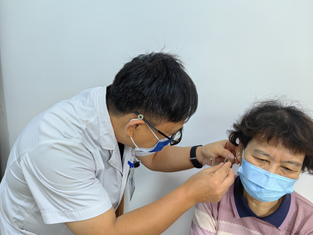 为患者进行耳穴压豆治疗