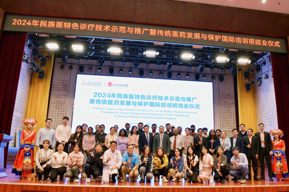 在国际培训班结业仪式上，广西国际壮医医院党委副书记、院长黄国东为学员们赠书