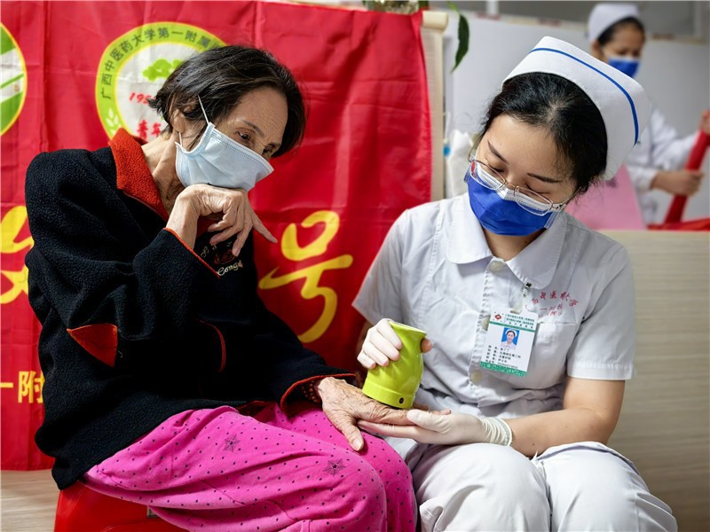 疼痛专科小组组长为老人做温通刮痧罐